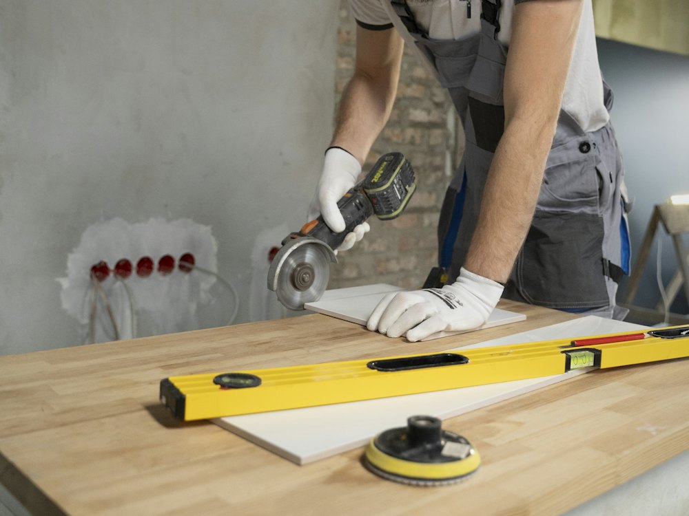 Worker cutting a tile with an angle grinder
